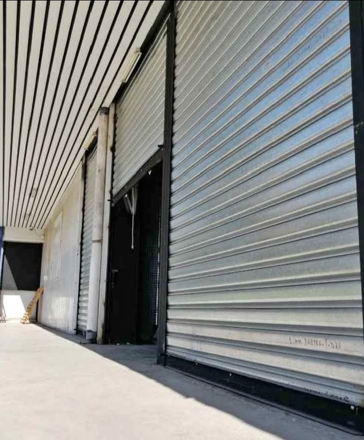 alt="Persiana metálica enrollable de local comercial parcialmente levantada — servicio de arreglo de persianas y cortinas metálicas en Chacarita (CABA), atención en el día y urgencias 24 hs."