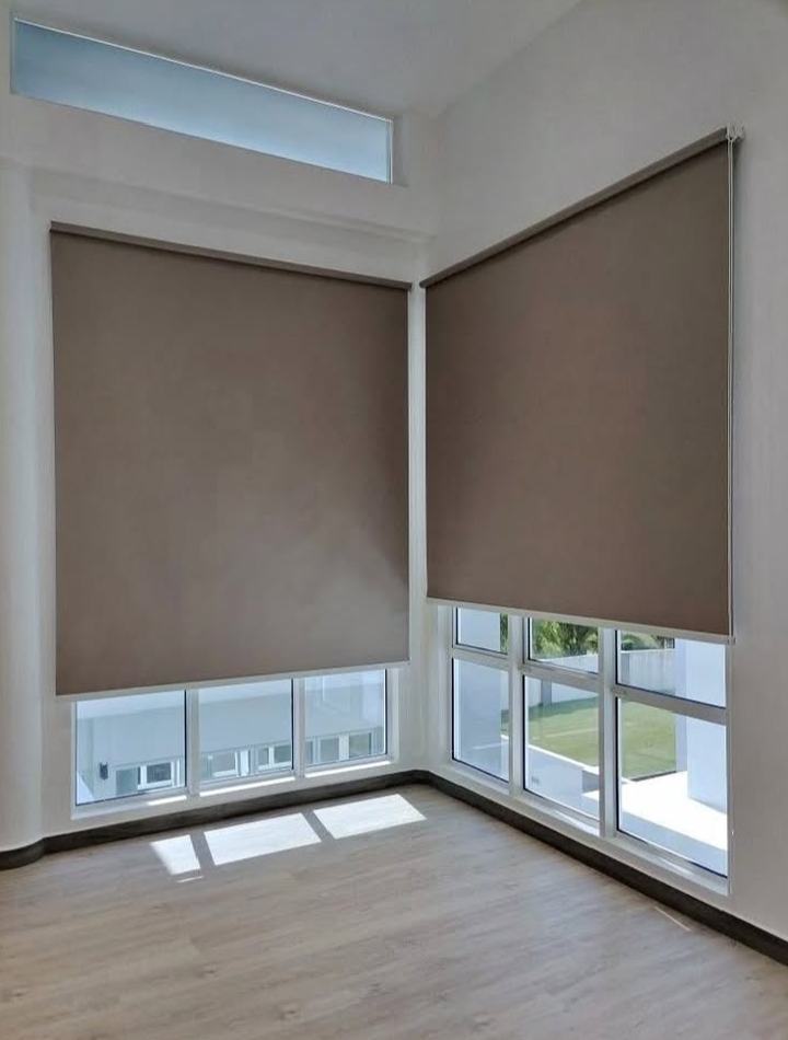 Cortinas roller blackout color taupe instaladas en ventanas esquinadas de living, Monte Castro (CABA)