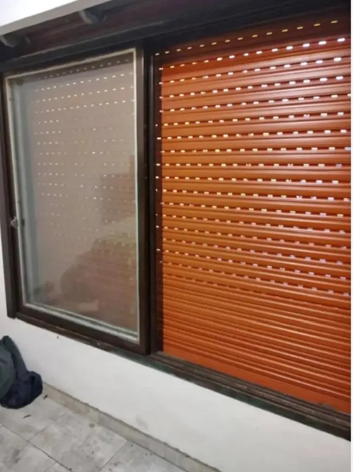 alt="Persiana de madera exterior instalada en ventana de vivienda en CABA">