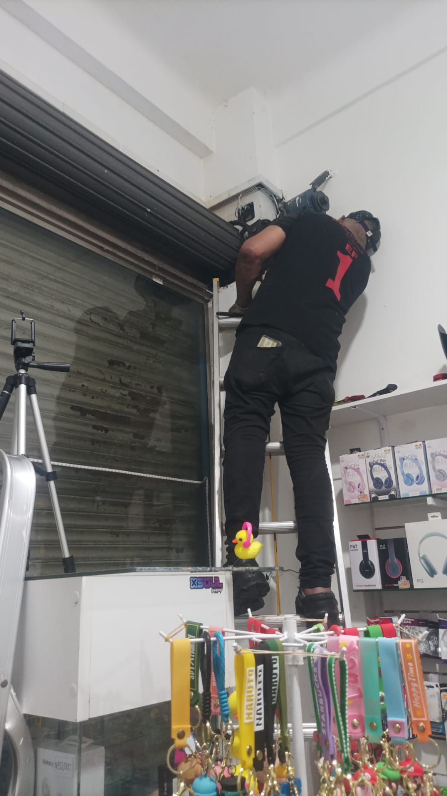 alt="Técnico reparando persiana metálica enrollable en local comercial de CABA">