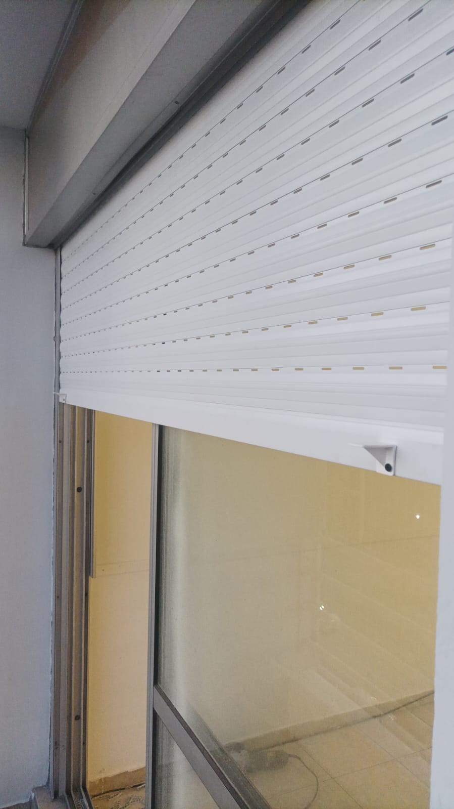 alt="Persiana de PVC blanca en ventana reparada y alineada en Capital Federal">