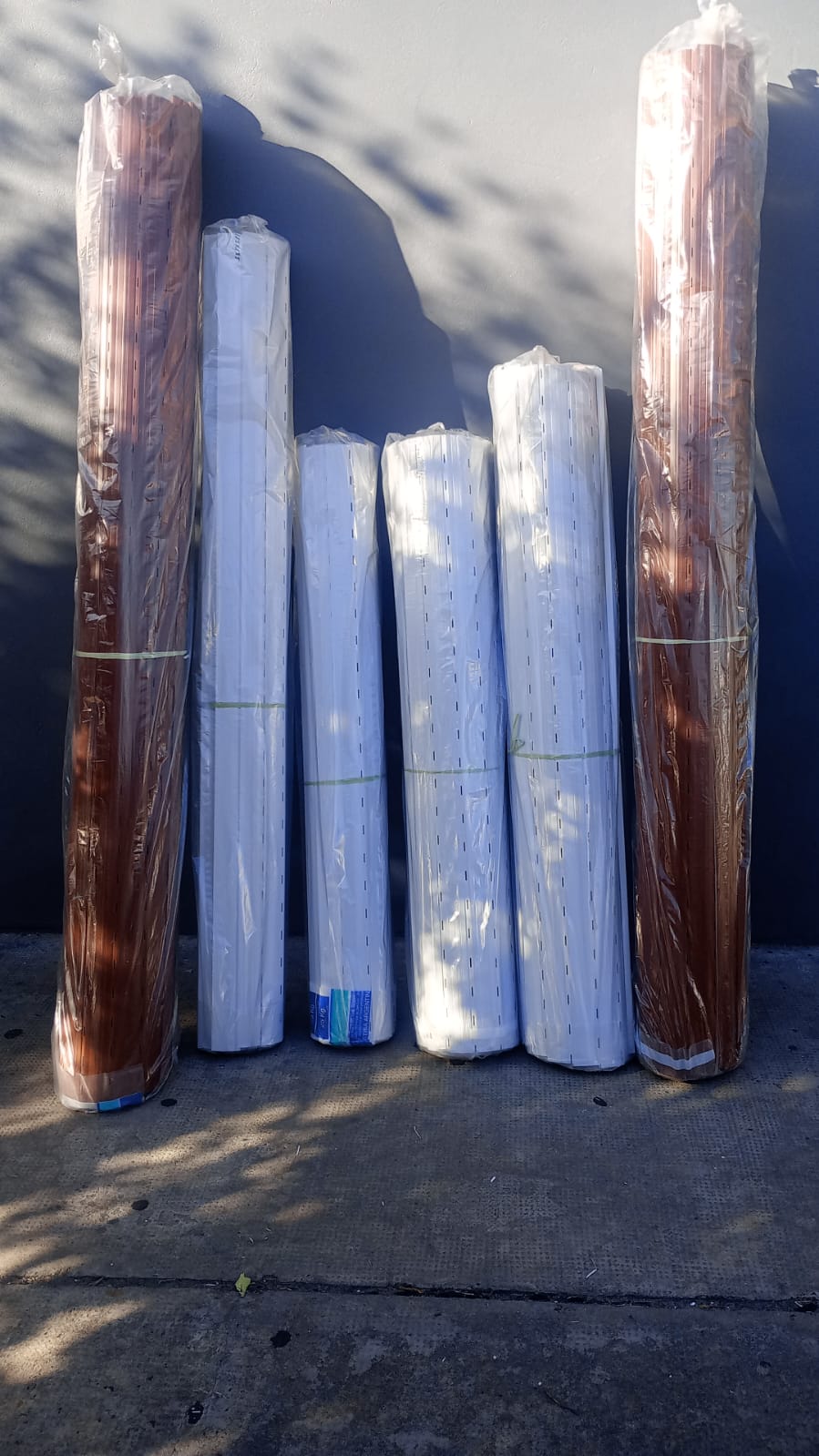 Rollos de persianas de PVC blancas y simil madera preparados para venta mayorista y minorista en CABA, fabricados a medida por Persianas CG.